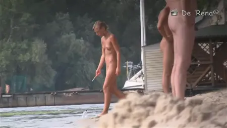 ათობით შიშველი ტურისტი Sunbathe Nudist Beach- ზე